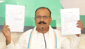 Harshvardhan Sapkal addressing a press conference while holding documents related to alleged bogus call center racket