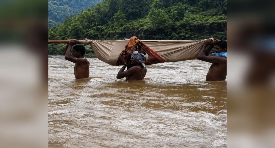 दुर्गम आदिवासी भागात बांबूच्या डोल्यातून नदी ओलांडून रुग्णाला उपचारासाठी नेताना ग्रामस्थ.