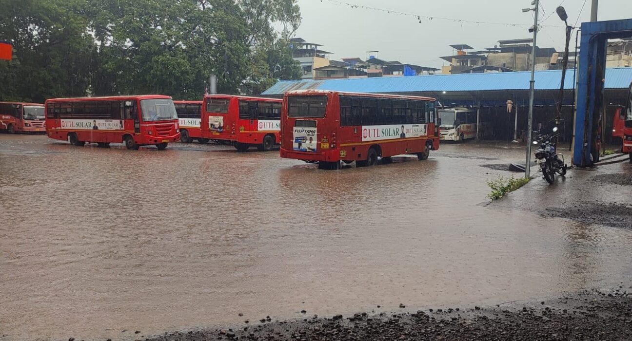 Multiple Maharashtra State Transport (ST) buses parked in floodwater at Mahad Bus Stand after heavy monsoon rain in Raigad district.