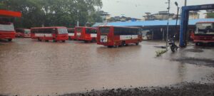 Multiple Maharashtra State Transport (ST) buses parked in floodwater at Mahad Bus Stand after heavy monsoon rain in Raigad district.
