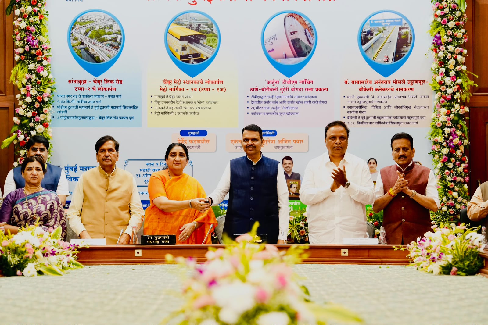 मुख्यमंत्री देवेंद्र फडणवीस मुंबईतील मेट्रो, उन्नत मार्ग आणि इतर पायाभूत प्रकल्पांच्या कार्यक्रमात उपस्थित असताना मंचावरील दृश्य.